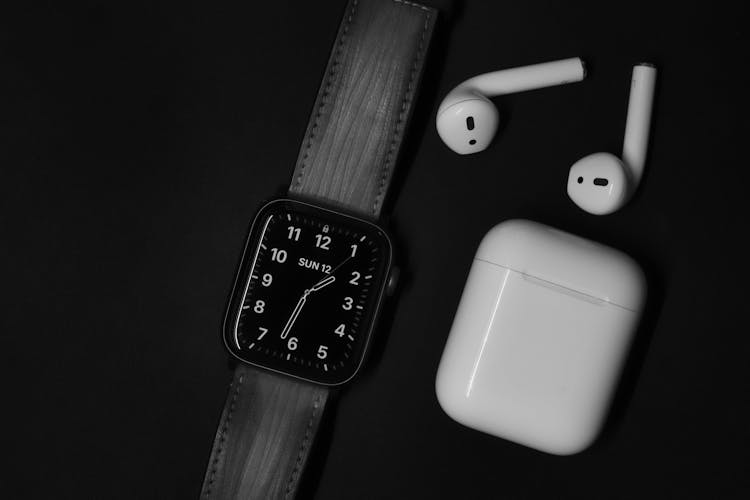 Apple Watch And Air Pods On Black Surface 