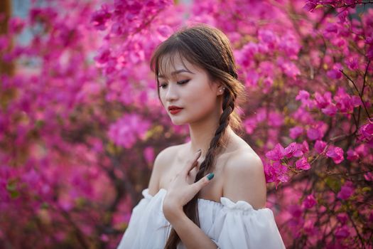Elegant portrait of a woman amidst blooming pink bougainvillea flowers, showcasing natural beauty.