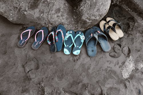 Assorted Flip-flops on Sand