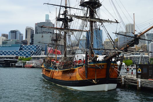 悉尼港里停泊着一艘老式船，背景是城市天际线