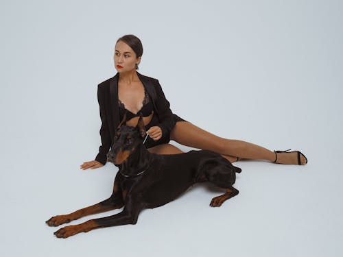 Free A Woman in a Lingerie Sitting on the Floor beside Her Pet Dog Stock Photo