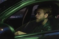 Man in Green Jacket Driving Car