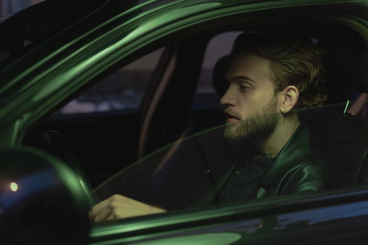 Man In Green Jacket Driving Car