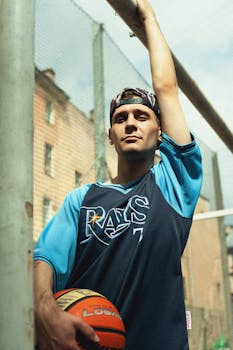 Caucasian man in sportswear holding a basketball in an outdoor court in Saint Petersburg.