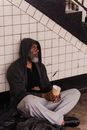 Man in Black Hoodie Sitting on White Ceramic Floor Tiles