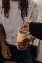 Person Holding Yellow and Green Plastic Cup