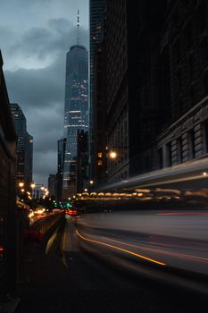 Urban night scene with skyscraper and light trails, evoking modern city life.