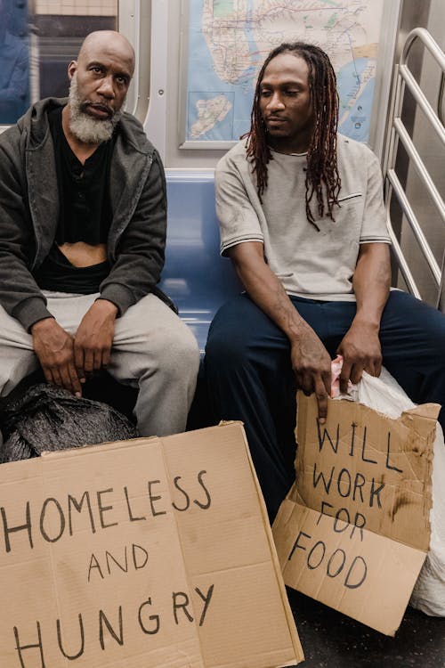 Men Sitting in a Train with Placards Made of Cardboards