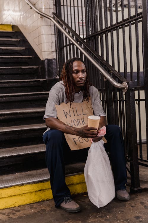 Homeless Man Sitting on Stairs