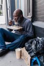 Man in Black Long Sleeve Shirt and Blue Pants Sitting on Gray Concrete Bench