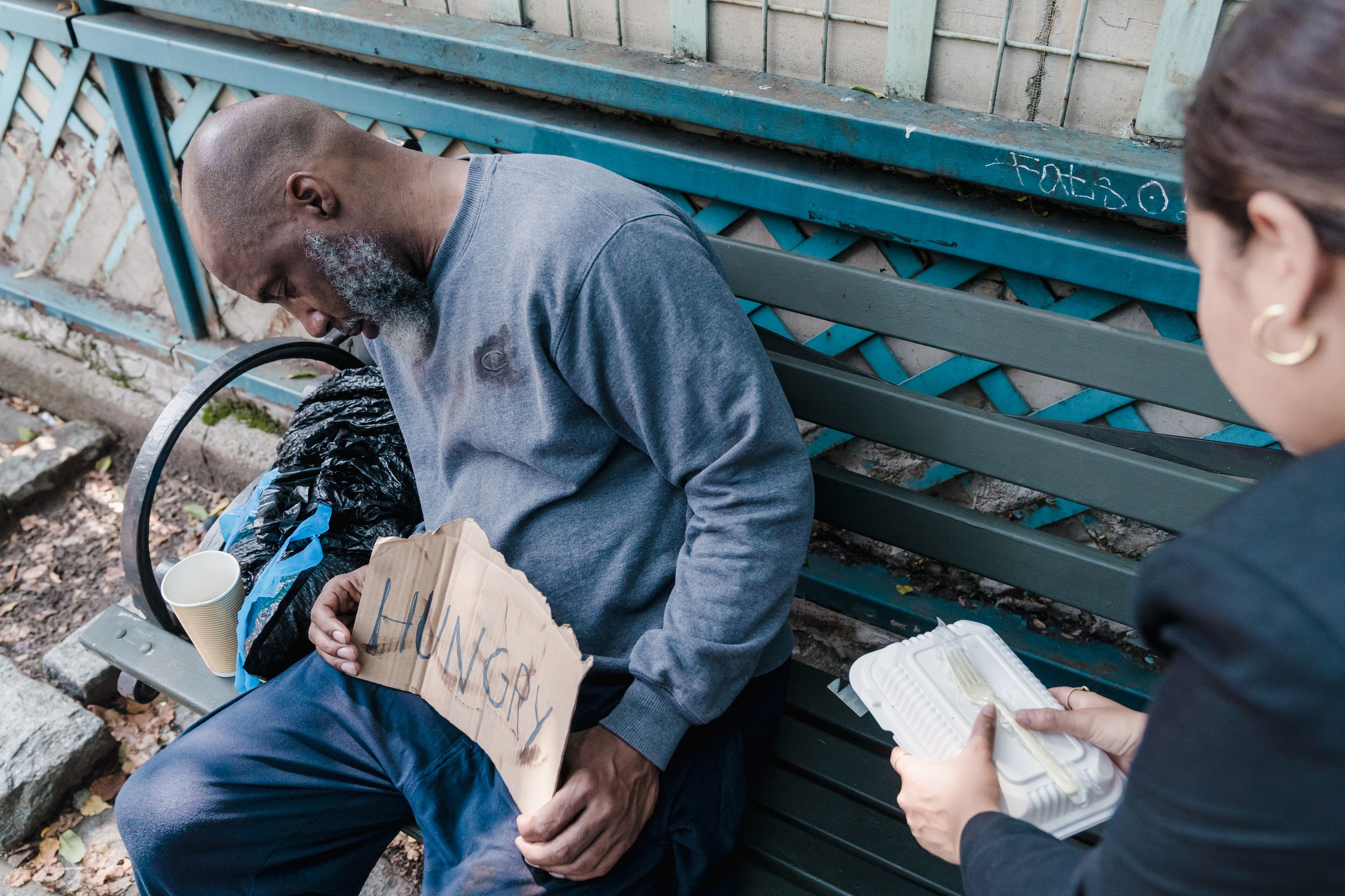 A volunteer sharing a meal with someone on the street