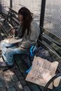 Woman in Gray Jacket and Blue Denim Jeans Sitting on Bench