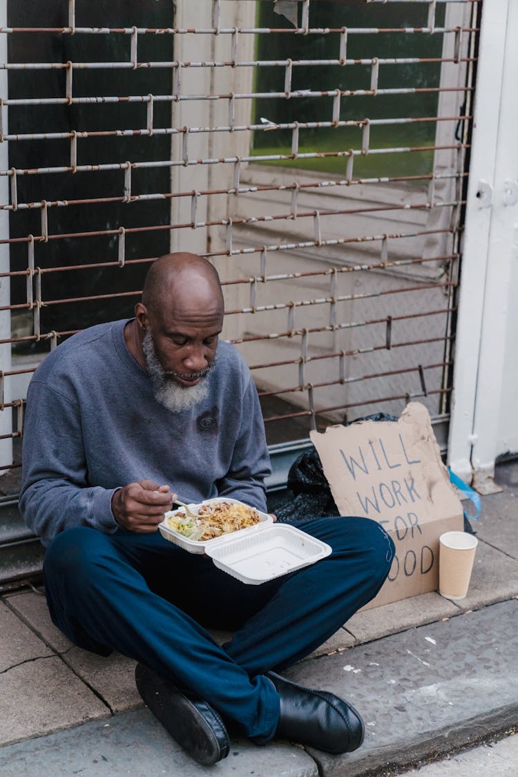 Man Eating Meal At Sidewalk