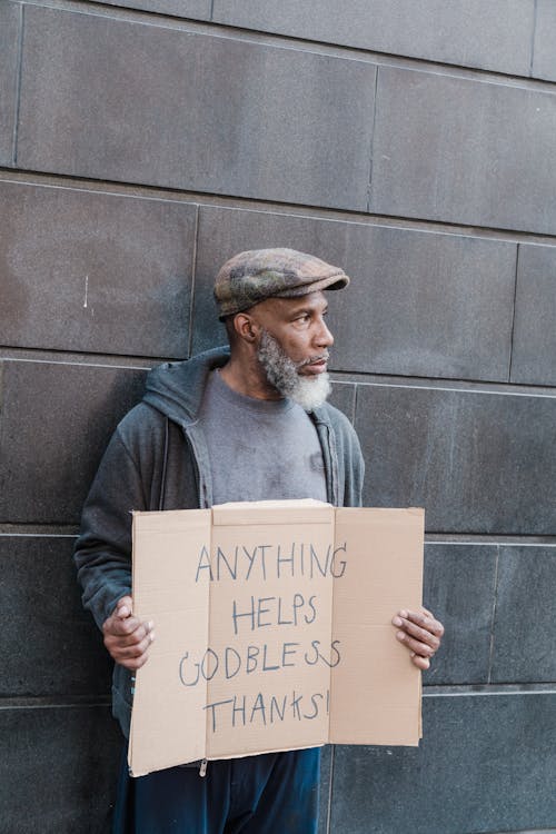 Free Homeless Man Holding a Cardboard Sign Stock Photo