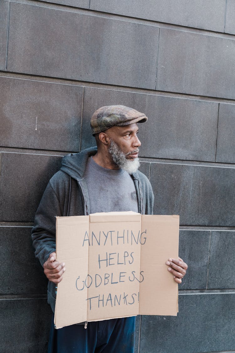 Homeless Man Holding A Cardboard Sign