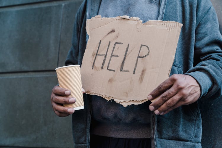 Man Holding Cup And Cardboard