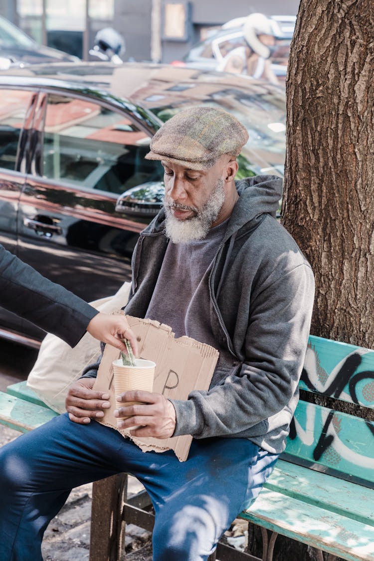 Photo Of A Beggar Receiving Money From A Person