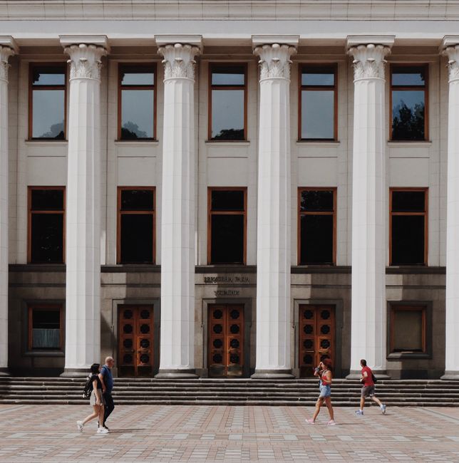 Elegant exterior of Ukraine's parliament building in Kiev with classical columns and pedestrians.
