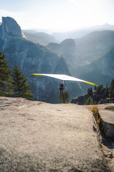 Experience the exhilaration of hang gliding in a stunning mountain setting, with expansive vistas and clear skies.
