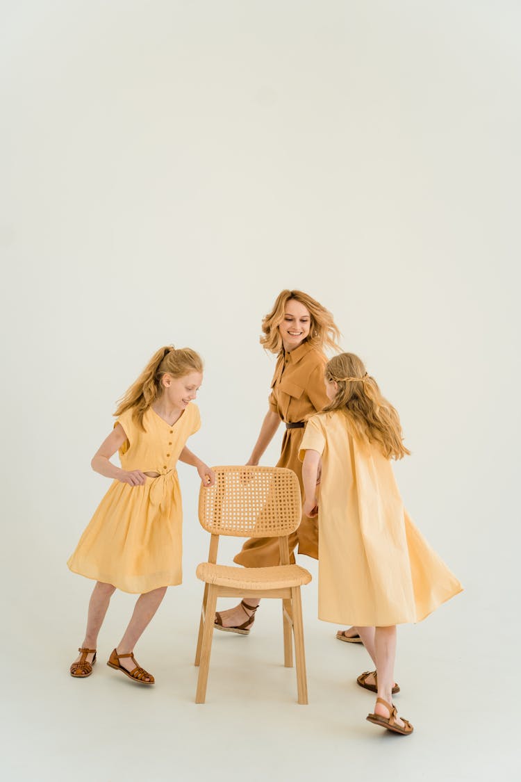 Woman And Girls Running Around A Chair