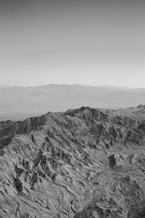 Free Black and white aerial photo of barren mountains showcasing dramatic geology. Stock Photo