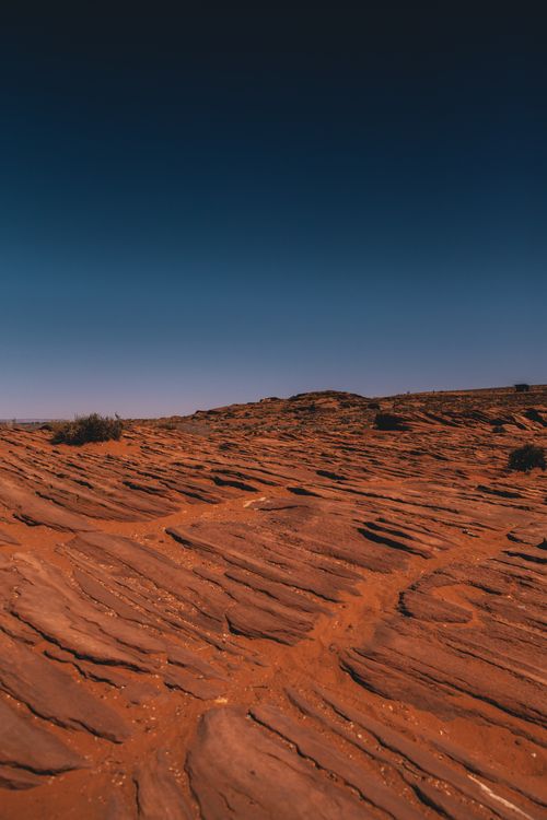 Free A vibrant desert scene showcasing the textured sandstone under a clear blue sky, ideal for nature lovers. Stock Photo