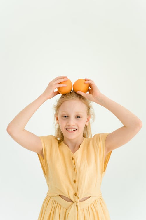 Girl Holding Oranges on Her Head