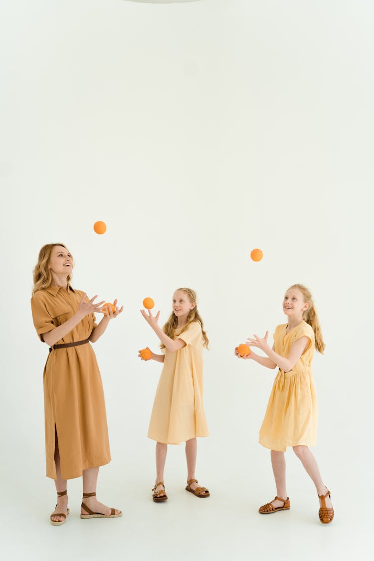 Woman Juggling Balls With Two Girls