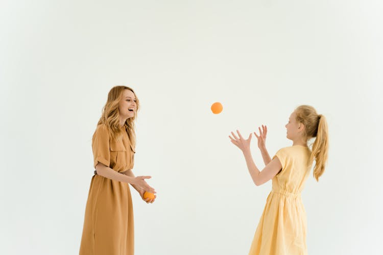 A Woman And A Girl Throwing A Ball