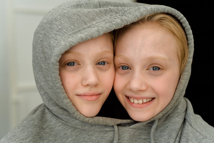 Twins With Heads Close Together In A Gray Hoodie