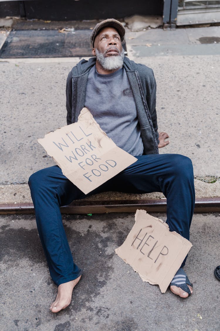 Man Sitting With Texts On Cardboards