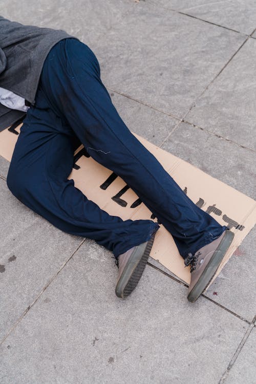 Free Person Lying Down on a Cardboard Sign Stock Photo