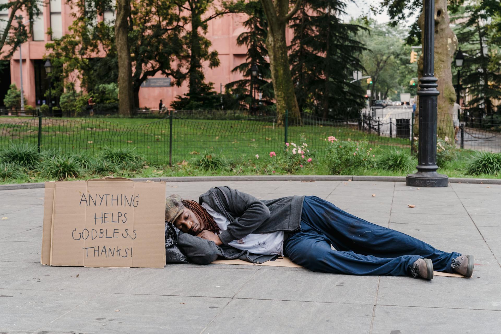 Man Sleeping on Sidewalk in City