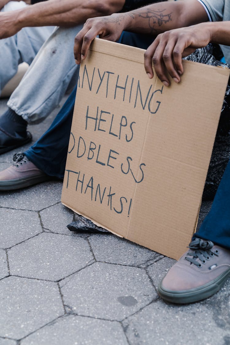 Person Holding Brown Cardboard Sign