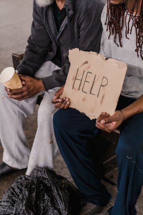 A Person Holding a Stained Cardboard with a Help Sign