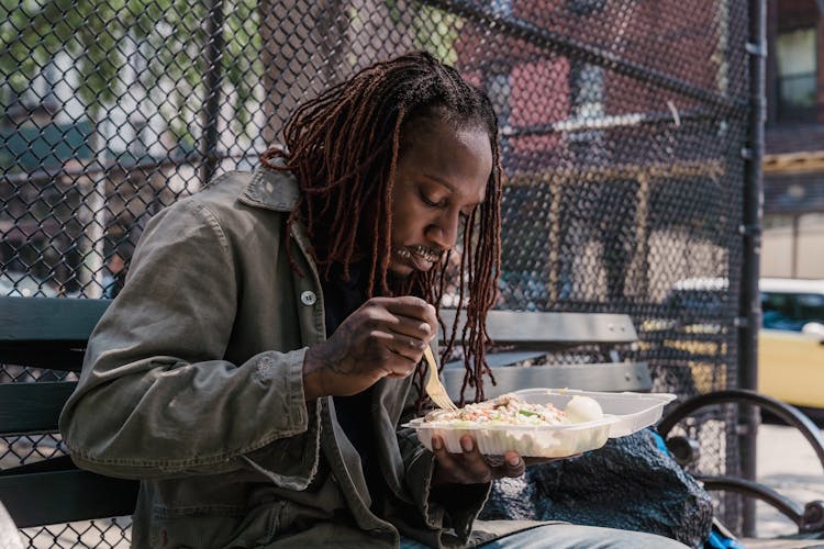 A Man Eating In A City