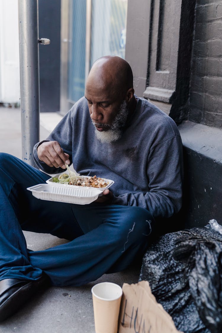 Homeless Man Eating On Street