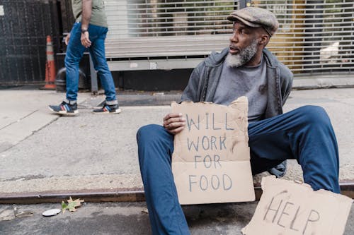 Free Homeless Man Sitting on the Sidewalk Stock Photo
