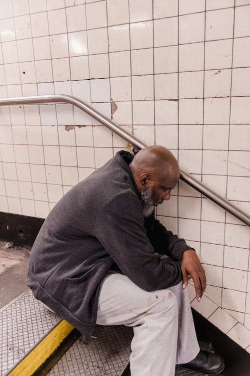 Homeless Man Sitting on the Concrete Stairs