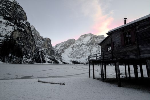 黎明时分，雪山和乡村小屋构成了一幅宁静的冬季景观