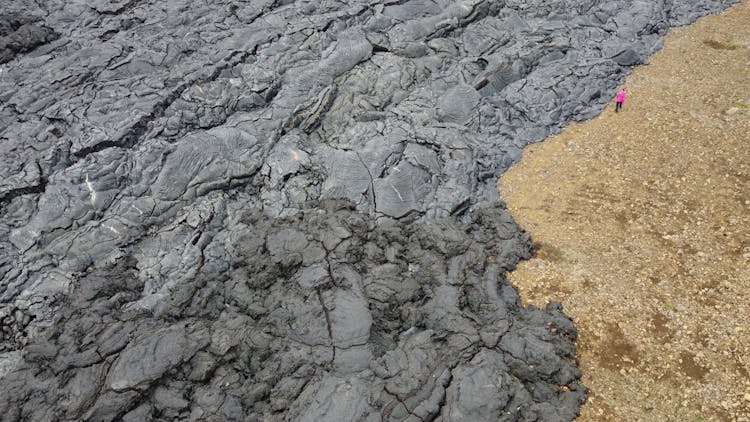 Person Walking Near Volcanic Soil