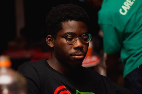 Selective Focus Photo of a Man in a Black Shirt Wearing Eyeglasses