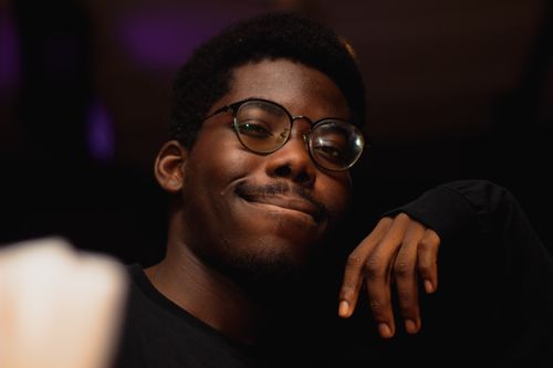 Free Portrait of a confident adult man with glasses smiling with a hand on his chin. Stock Photo
