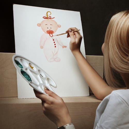 A Person Painting a Baby on White Illustration Board