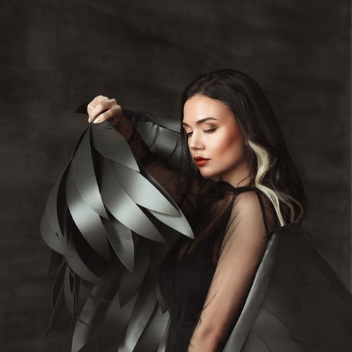 Free Stunning portrait of a woman in a dark, feather-like costume, showcasing elegance and artistry. Stock Photo