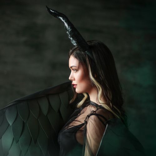 Free Striking side view portrait of a woman in a demon costume with horns. Stock Photo