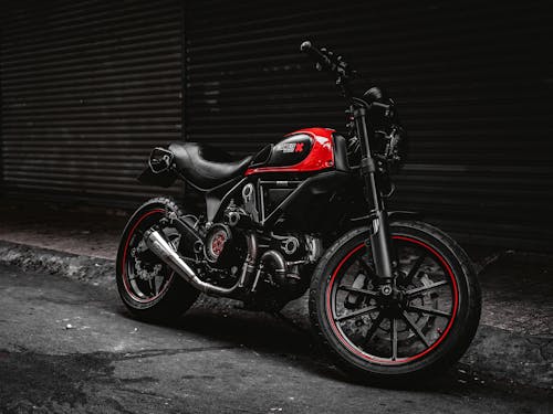 Black and Red Motorcycle Parked Beside the Roller Shutter