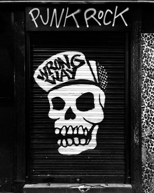 Free Funky skull graffiti on locked roll down black door Stock Photo