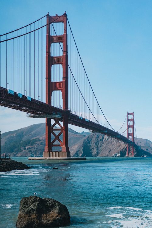 Free Iconic view of the Golden Gate Bridge spanning the bay in San Francisco, CA under a clear blue sky. Stock Photo