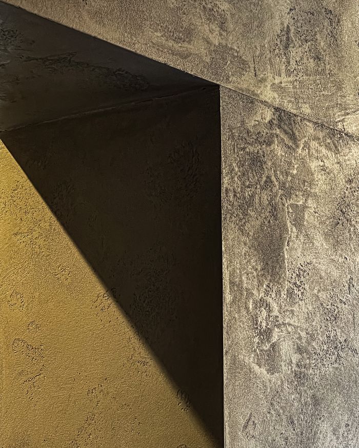 Raking light across a rough plaster wall, by Nikita Telenkov on Pexels